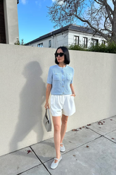 a lady wears a round neck knitted light blue cardigan